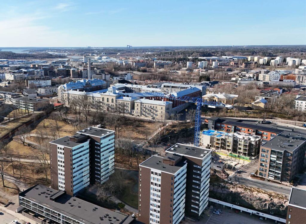 Ilmakuvaa turun rakennuksista. Maisemassa näkyy nosturi ja rakennustyömaa sekä valmiita kerrostaloja.